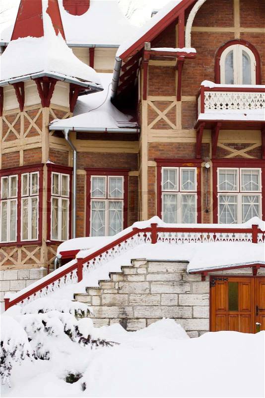 The front of a older home covered in deep snow, stock photo