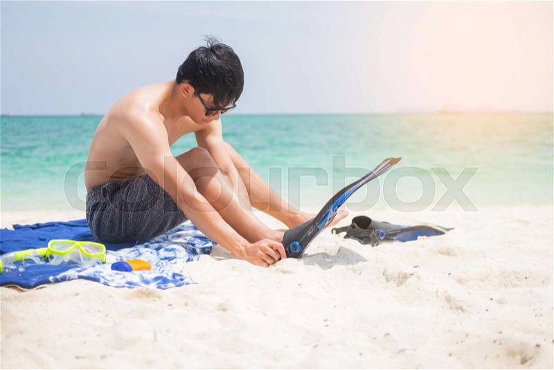 Vacation Backside of man holding snorkeling gear on tropical on the beach on summer travel destination, stock photo
