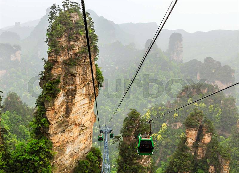 Cablecars on its way to the top among sandstone pillars and peaks with green trees and mountains panorama, Zhangjiajie national forest park, Hunan province, China8, stock photo