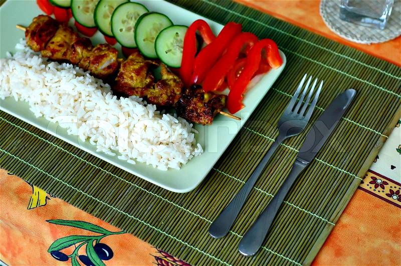 Meat on a stick with rice and vegetables, stock photo