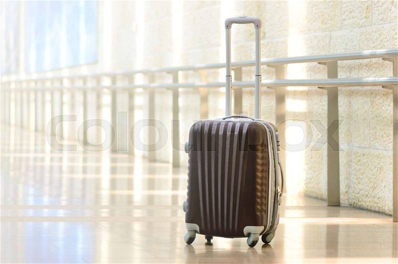 Packed travel suitcase, airport. Summer holiday and vacation concept. Traveler baggage, brown luggage in empty hall interior. Copy space, stock photo