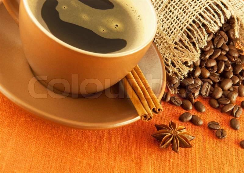 Cup of coffee and bag of grains in bulk on a orange background, stock photo