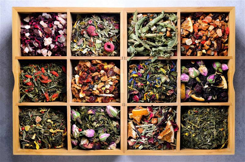 Assortment of dry tea in wooden box. Tea types: green, black, floral, herbal, mint, melissa, ginger, apple, rose, lime tree, fruits, orange, hibiscus, raspberry, cornflower, cranberry, stock photo