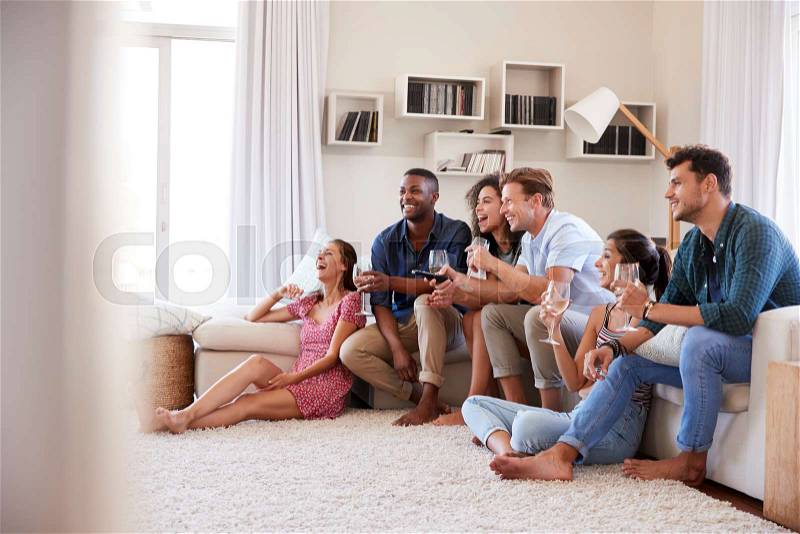 Group Of Friends Relaxing At Home Watching TV Together, stock photo