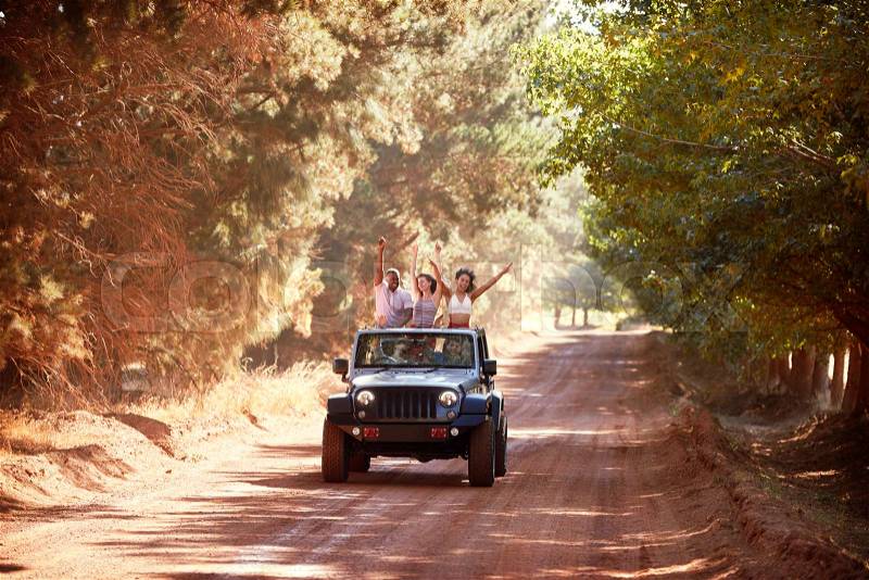 Friends having fun driving in an open top jeep, stock photo