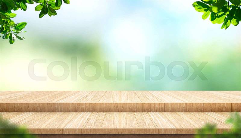 Empty step plank wood table top with blur tree in park with bokeh light background and leaves foreground,Mock up template for display of your design,Banner for advertise of product,panorama view, stock photo