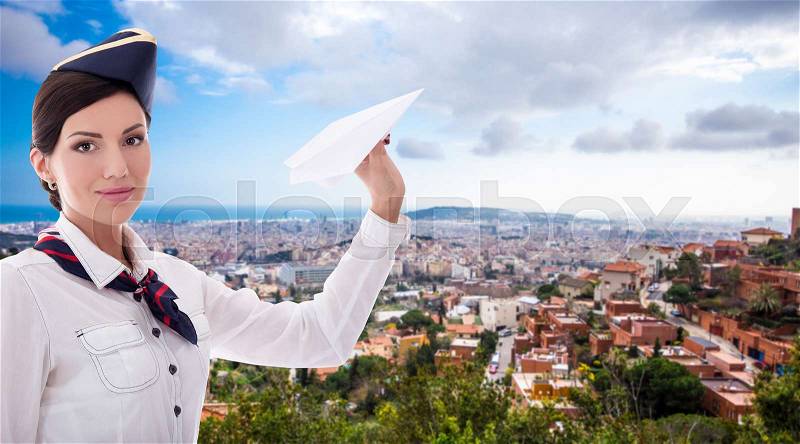 Travel concept - beautiful stewardess with paper plane over aerial view of Barcelona, stock photo