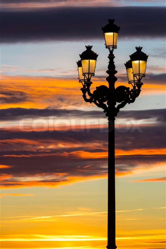 Lighted lanterns against the backdrop of the setting sun on the streets of Madrid, stock photo