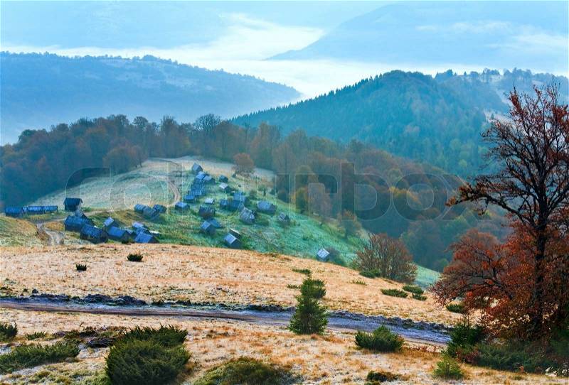 Autumn misty morning mountain hill with country road and cattle sheds Carpathian Mt\'s, Ukraine, stock photo