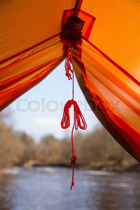 A look through the entrance of the tent. Orange camping tent in an early spring. Exit door, stock photo