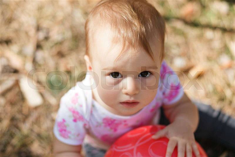 Sweet overweight baby girl looking to camera. Close up portrait of a child. Cute toddler with gray eyes forest portrait, stock photo