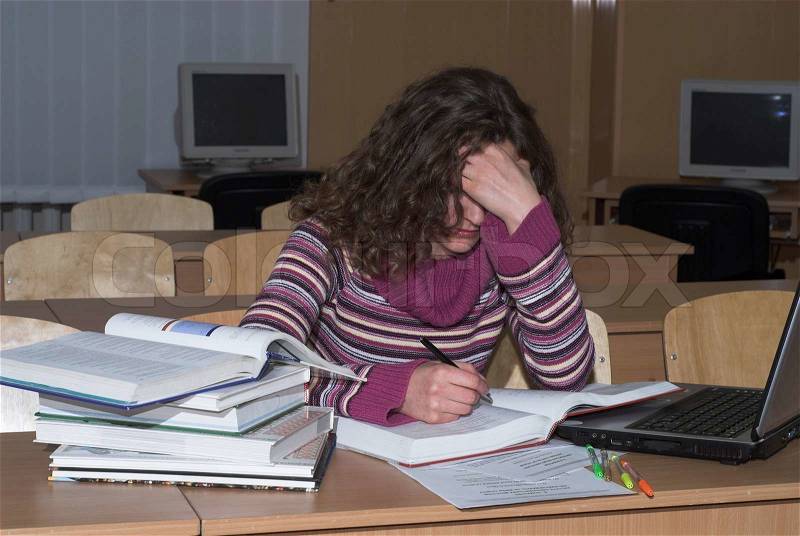 Young female srudent is studying hard, stock photo