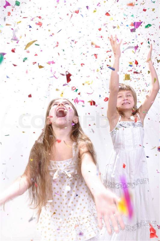 Two happy excited laughing girls under sparkling confetti shower, stock photo