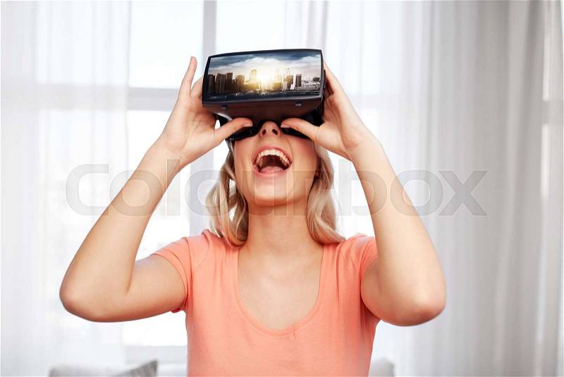 Technology, augmented reality, entertainment and people concept - happy young woman with virtual headset or 3d glasses playing video game with singapore city on screen at home, stock photo