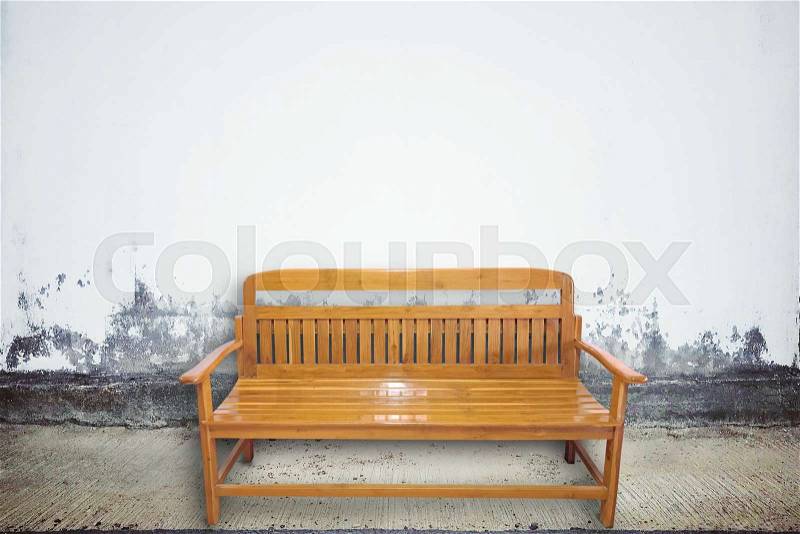 Wood chair on aged street with concrete wall texture and background, stock photo