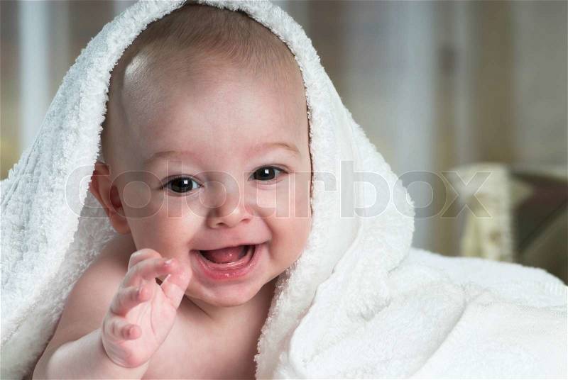 Toothless baby is smiling in bed, stock photo