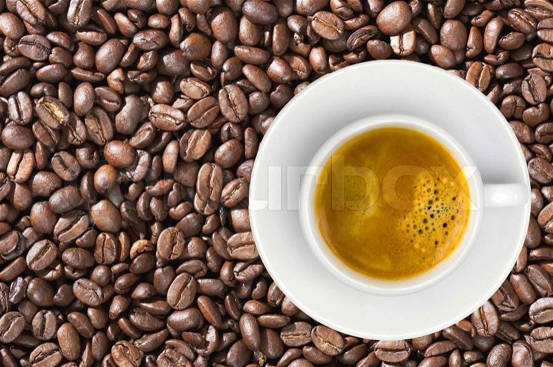 White cup of coffee espresso over coffee beans background, stock photo
