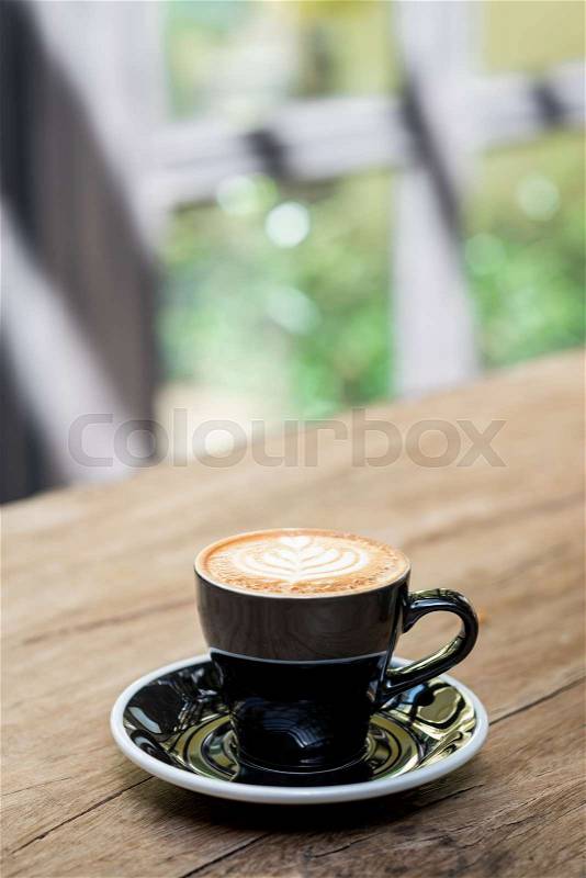 Hot cappuccino coffee cup with tree shape latte art milk foam on wood table near window in garden in sunlight at cafe restaurant.Leisure lifestyle.food and drink, stock photo
