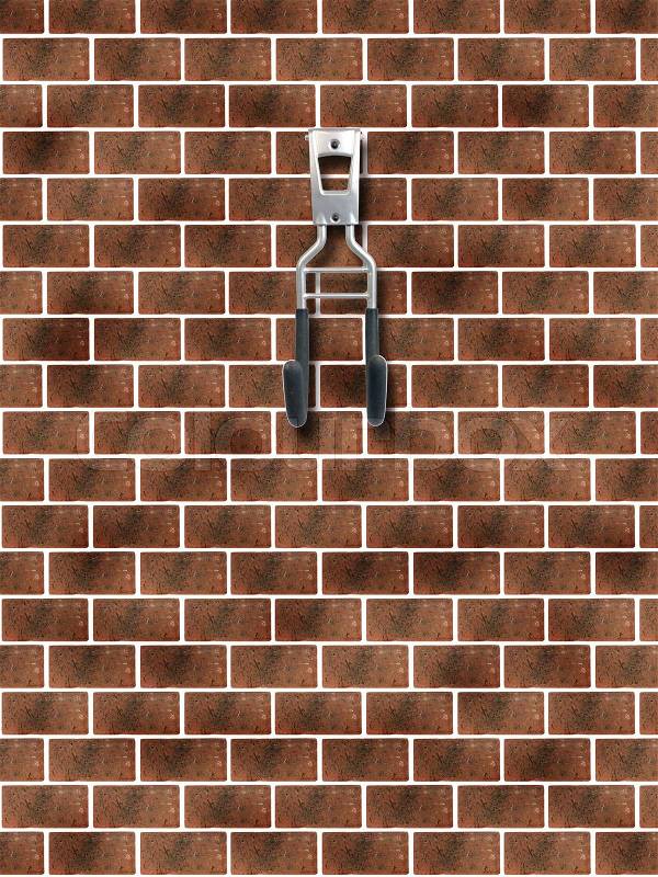 A garage storage hook on a red brick wall, stock photo