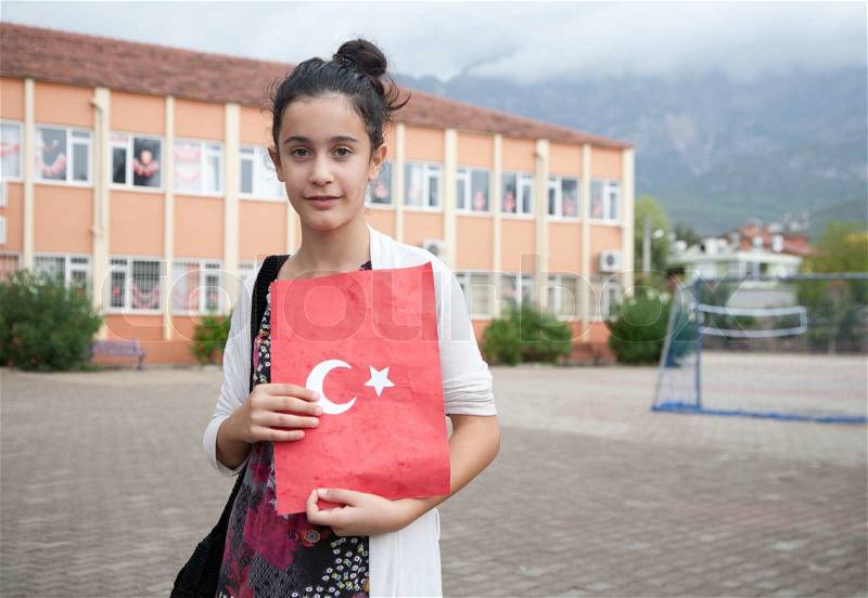Turkish schoolgirl celebrates Turkish Republic Day in Tekirova town, Turkeyon 29 October, 2010 , holding handmade folder with national symbols with handwritten national anthem inside, stock photo