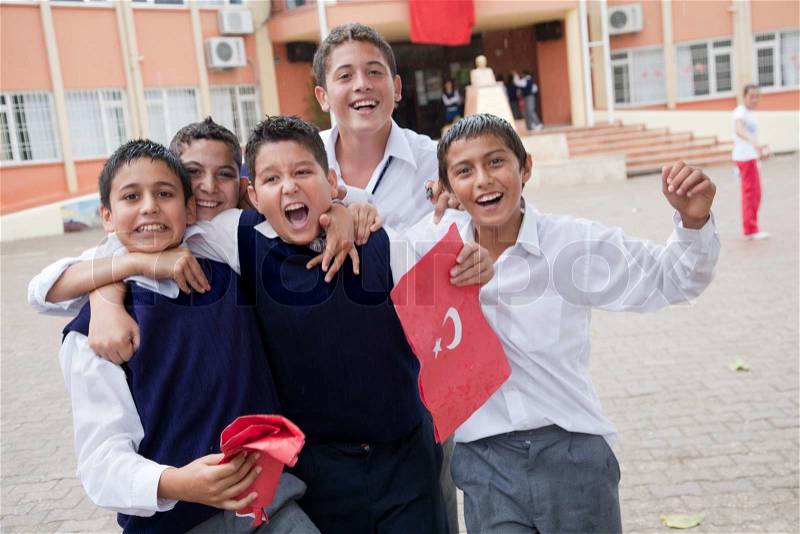 Happy turkish schoolchildren celebrate Turkish Republic Day in Tekirova town, Turkeyon 29 October, 2010 , holding handmade folder with national symbols with handwritten national anthem inside, stock photo