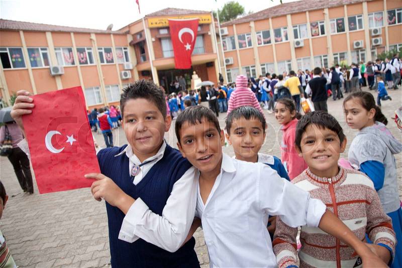 Happy turkish schoolchildren celebrate Turkish Republic Day in Tekirova town, Turkeyon 29 October, 2010 , holding handmade folder with national symbols with handwritten national anthem inside, stock photo
