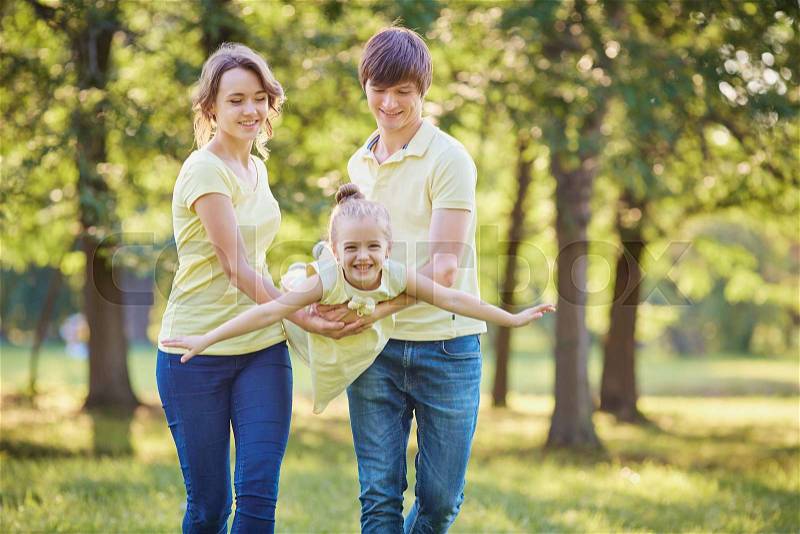 Happy family plays in the park in the summer, stock photo