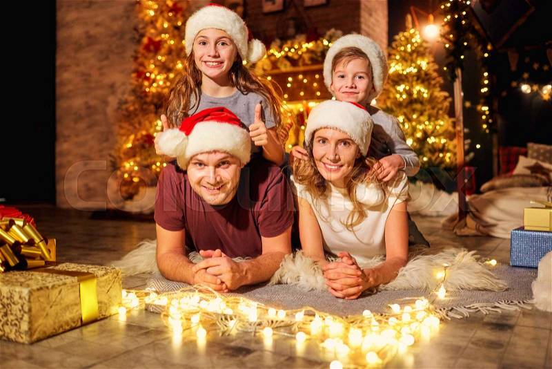Happy family in a room with a Christmas tree on Christmas Day, stock photo