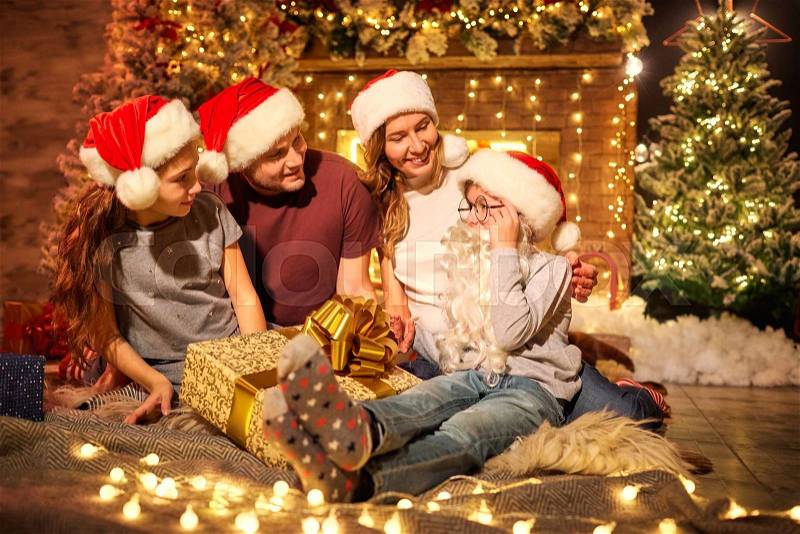 Happy family in a room with a Christmas tree at Christmas, stock photo