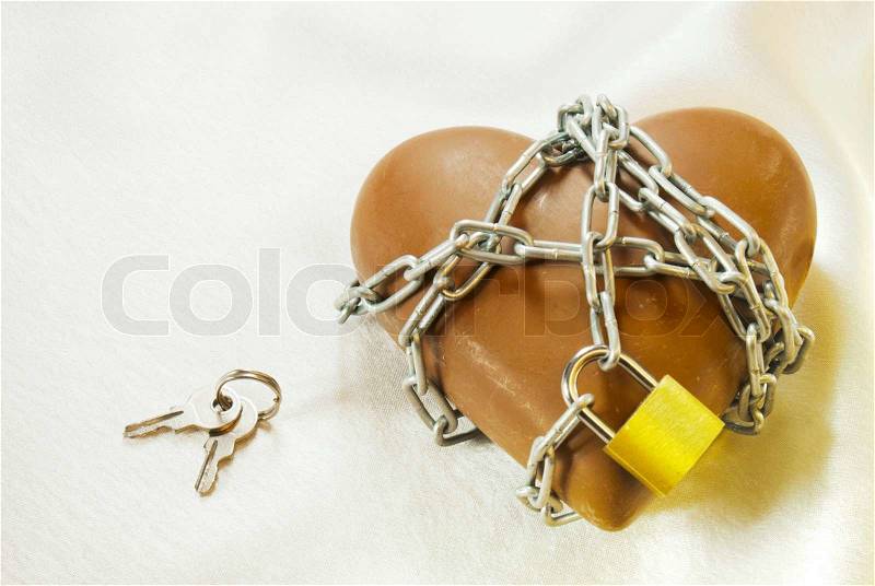 Heart shaped chocolate tied up with chains with lock and keys, stock photo