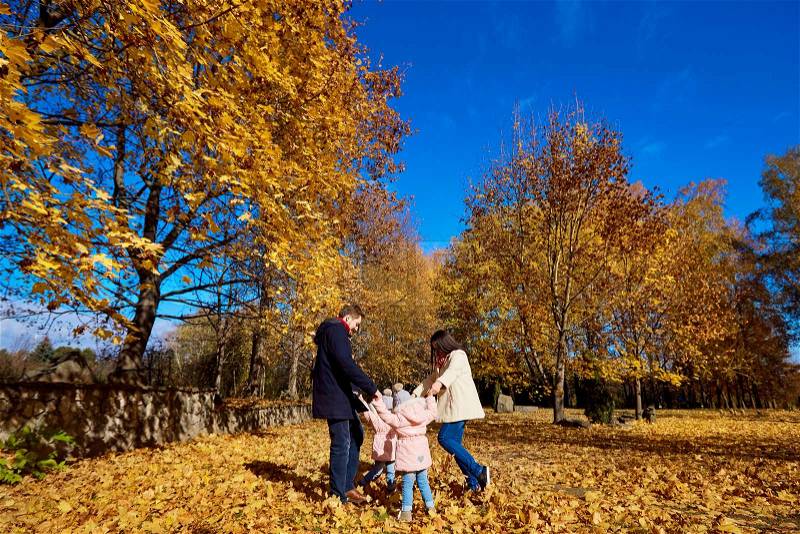 Happy family playing in the park beautiful autumn. Mother, father and children together in nature, stock photo