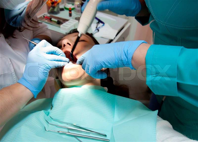 The dentist treats teeth to the patient, surgical instruments, stock photo
