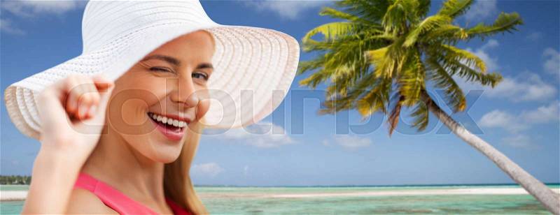 Summer, fashion and people concept - portrait of beautiful smiling woman in sun hat over tropical beach background in french polynesia, stock photo