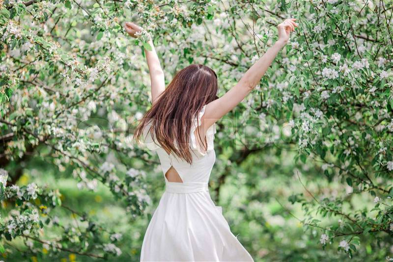Spring mood, beautiful woman smell flowering tree, enjoying nature, white floral garden. Beautiful woman enjoying smell in spring cherry garden, stock photo