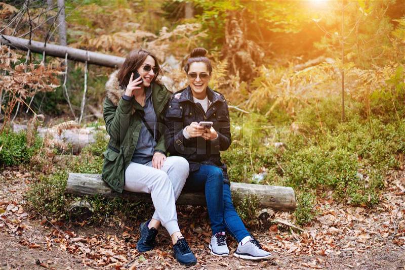 Two beautiful girls sat down to rest in the forest, stock photo