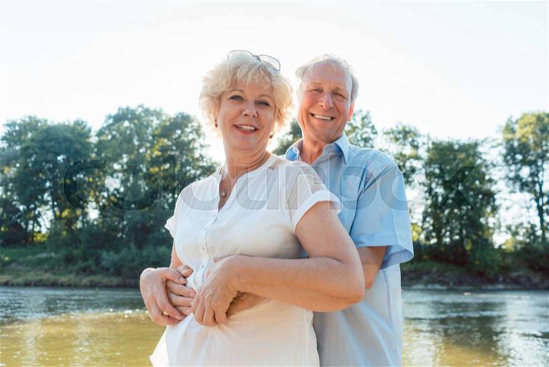 Low-angle side view portrait of a romantic senior couple in love enjoying a healthy and active lifestyle outdoors in summer, stock photo