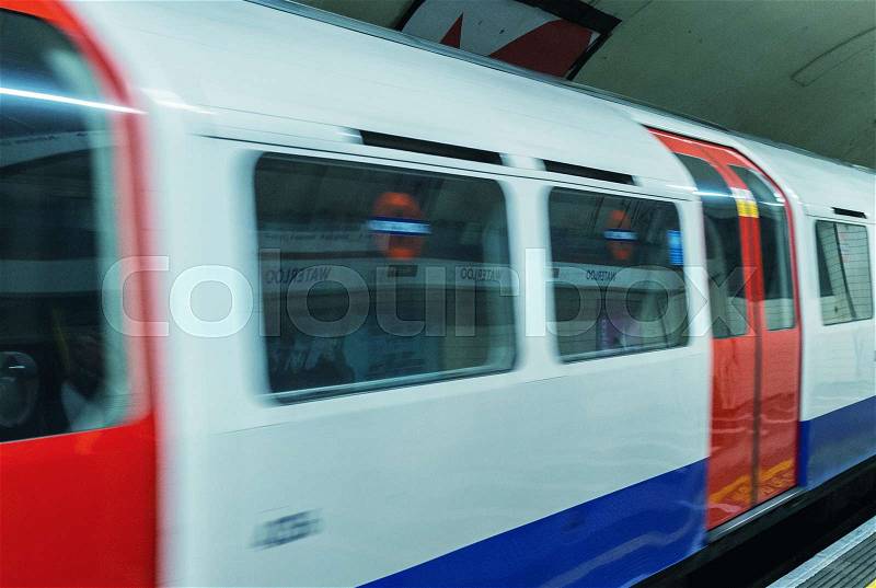 A subway train in motion arriving at a London underground train station, stock photo