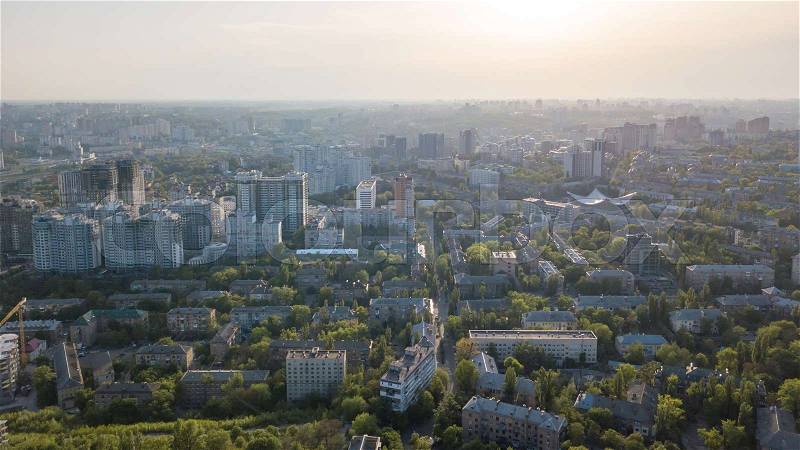 Aerial photography from the drone, bird\'s eye view to the Kiev old building with green spaces and the newly built houses, a new microdistrict of the city at sunset in the summer, stock photo