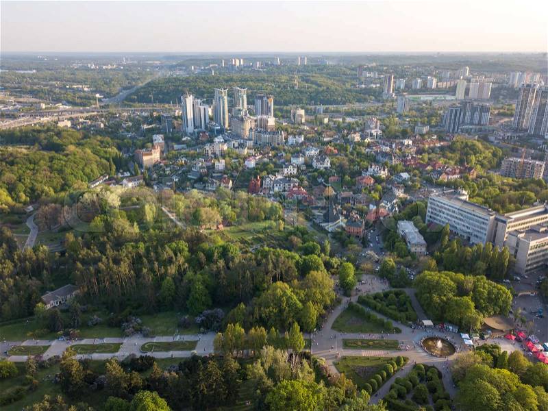 Aerial photography from the drone, bird's eye view to modern buildings of the Pechersk district and recreational area National Botanic Gardens in the city of Kiev at sunset in the summer, stock photo