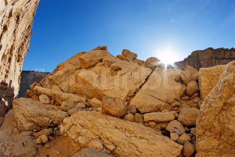 Run setting behind the yellow sandstone rock in the desert, stock photo