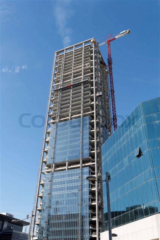 Lifting crane at skyscraper construction site, stock photo