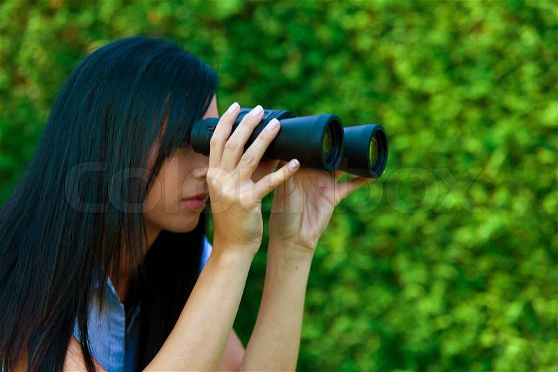 Young woman with binoculars looking to the future, stock photo