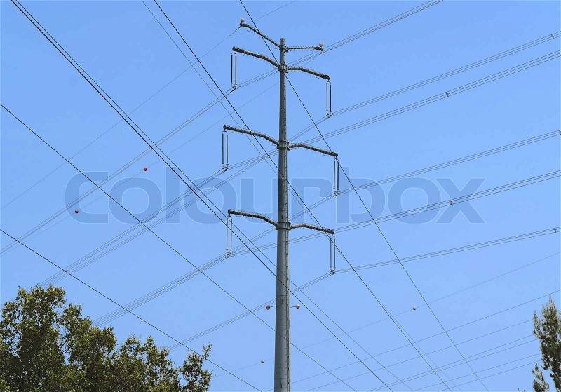 Crossed wires and steel support of overhead power transmission line on sky background, stock photo