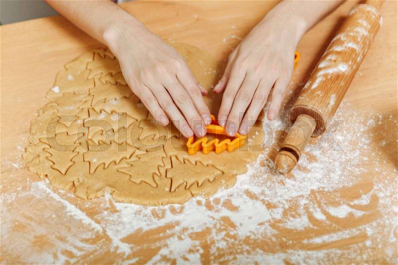 The European woman hands with healthy clean wich cook Christmas ginger biscuit in the kitchen. Happy mom 30-35 years roll out dough and cut out cookies at home, stock photo