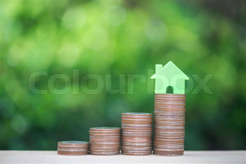 Home model on the growing coin stack for concept of money saving for home buying fund, stock photo