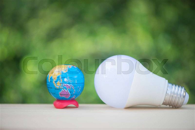LED bulb and globe model with green nature background for saving energy concept, stock photo