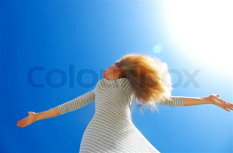 Beautiful female over blue clean sky conceptual image of healthy happy lifestyle, stock photo