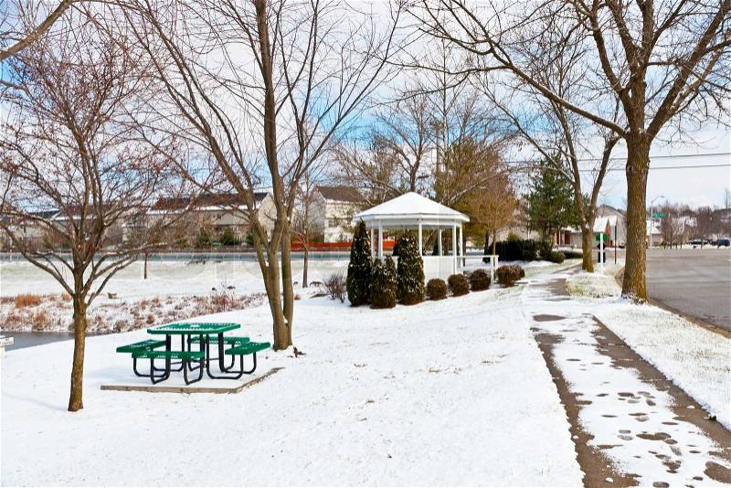 Winter city scene with a picnic table and gazebo at neighborhood recreation area, stock photo