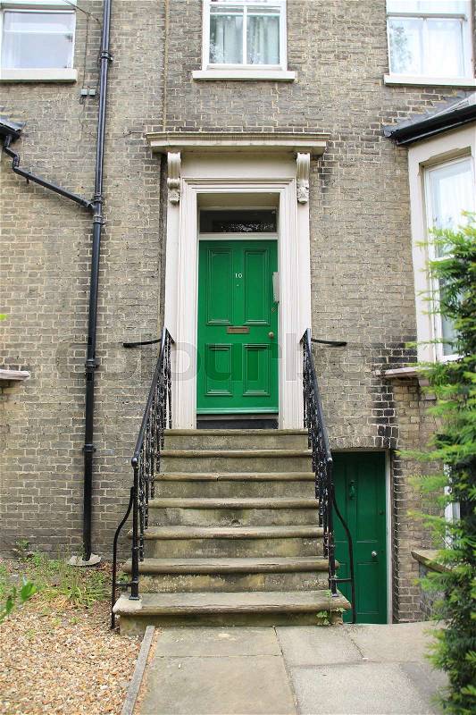 Staircase and the striking green front door of the student residence in the city Cambridge in England, stock photo