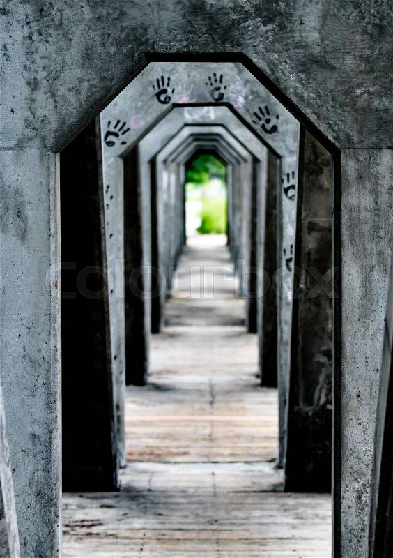 Stone covered corridor with wooden slats on floor and hand prints, stock photo